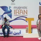 Una mujer. Posa frente al eslogan de la campaña turística oficial del país.