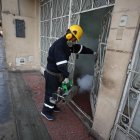 Un trabajador que fumiga en una vivienda del distrito El Agustino como medida preventiva contra el dengue en Lima (Perú).
