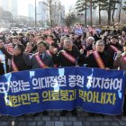 Los médicos portan una pancarta mientras marchan hacia la oficina presidencial en el distrito de Yongsan, Seúl, Corea del Sur, el 25 de febrero de 2024.