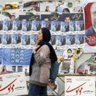 Una mujer iraní pasa por delante de carteles electorales de candidatos a las elecciones parlamentarias que se celebran en Irán el 1 de marzo de 2024.