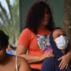 Personas esperan para recibir atención médica en una tienda de campaña para tratar casos sospechosos de dengue en Brasil.