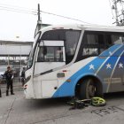 La moto quedó debajo del transporte urbano, mientras que los cascos de los ocupantes quedaron tirados en la avenida.