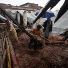 La gente recoge sus pertenencias de su casa que se derrumbó tras un fuerte aguacero en Peshawar, Pakistán,