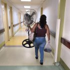 Una mujer lleva un ventilador a la sala donde está internado su paciente, en el hospital Teodoro Maldonado Carbo, del IESS.