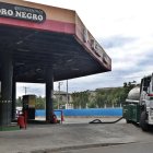 Un carro tanque de combustibles abastece una gasolinera