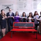 Símbolo. Entre dos aliadas correístas, en la plaza de acceso al salón plenario, el presidente Henry Kronfle inaugura el banco rojo contra el femicidio.