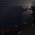 Una persona deposita un clavel en memoria de las víctimas del 11-M.