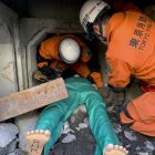 Efectivos del cuerpo de bomberos de Tokio llevan a cabo una demostración del rescate de una víctima atrapada bajo escombros.