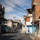 Una joven vestida con uniforme escolar camina en una calle de una zona popular, este miércoles en Caracas.