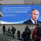 Ciudadanos pasan frente a una gigante pantalla digital con la imagen del presidente Vladimir Putin.