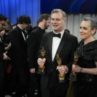 Christopher Nolan y su esposa, Emma Thomas, sostienen sus estatuillas doradas.
