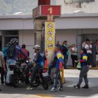 Varias personas hacen fila para abastecerse de combustible