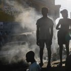 Varias personas observan el cadáver de una persona en el suelo este lunes 18 de marzo de 2024, en Puerto Príncipe (Haití).