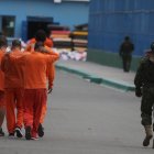 Un militar custodia a reclusos mientras se trasladan dentro de la cárcel de Cotopaxi.