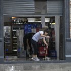 Una persona evacua el agua de su negocio en medio de un aguacero este miércoles 20 de marzo de 2024, en La Plata, provincia de Buenos Aires (Argentina).