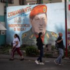 Caracas. Varias personas ladean un mural del fallecido Hugo Chávez.