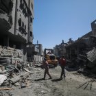 Palestinos buscan personas desaparecidas bajo los escombros de una casa destruida tras un ataque aéreo israelí, en el campo de refugiados de Al Nusairat, sur de la Franja de Gaza, 20 de marzo de 2024.