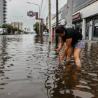 Una mujer en medio de una calle inundada por la lluvia el 20 de marzo de 2024, en Buenos Aires
