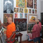 Arte. Jorge Ganín pinta un cuadro en el bar como parte de una muestra de su arte en vivo, mientras visitantes del sitio observan las obras.