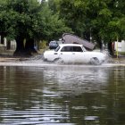 Un auto cruza por una calle anegada por las fuertes lluvias este sábado en La Habana (Cuba).