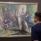 Un visitante observa las obras del artista cubano Wifredo Lam