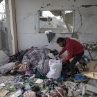 Una palestina desplazada que revisa entre los escombros de su casa tras un ataque israelí en Rafah, en el sur de la Franja de Gaza.