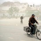 Un hombre sobre una bicicleta después de una tormenta de arena en China.