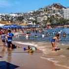 MEX3232. ACAPULCO (MÉXICO), 30/03/2024.- Fotografía de bañistas en una playa, el 29 de marzo de 2024, en el balneario de Acapulco (México). Aunque aún permanecen restos de la destrucción causada por el histórico huracán Otis, el turismo ha revivido esta Semana Santa en el puerto mexicano de Acapulco, estado de Guerrero, sur de México, con playas llenas y una ocupación cercana al 90 % en 177 hoteles. EFE/ David Guzmán