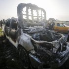 La gente observa el automóvil destruido de la ONG World Central Kitchen (WCK) a lo largo de la carretera Al Rashid, entre Deir Al Balah y Khan Younis en el sur de la Franja de Gaza, el martes 2 de abril de 2024.