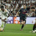 El delantero brasileño del Real Madrid Vinicius Jr. (i) se escapa con el balón de los jugadores de Manchester City