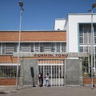 Personas aguardan en la puerta de una unidad educativa pública de una zona popular, en Caracas (Venezuela).