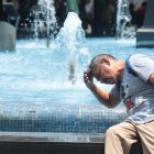 Un ciudadano se moja en una pileta en el centro de Guayaquil.