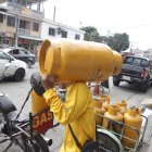 Guayaquil. Una persona que trabaja llevando tanques de gas camina al domicilio de uno de sus clientes.