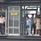 Las personas esperan los buses en las paradas