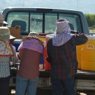 Una familia tomando agua durante un descanso en un campo agrícola.