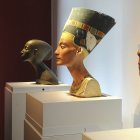 Una mujer que observa el busto de Nefertiti
