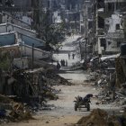 Varios palestinos caminan entre edificios destrozados en Jan Yunis tras un ataque israelí.