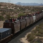 Migrantes viajan en el techo de un tren conocido como "La bestia", el 25 de abril de 2024 en Ciudad Juárez (México).