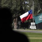 Las banderas de Chile y la institución de Carabineros a media asta en la Escuela de Carabineros, este sábado en Santiago (Chile)
