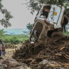 Nairobi. Personas observan un carro que fue arrastrado por un río.