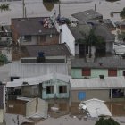 Personas esperan ayuda en el techo de su casa durante una operación de rescate del ejército brasileño junto con los bomberos en Canoas (Brasil).