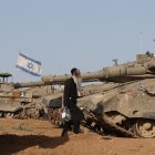Un judío ultraortodoxo pasa junto a vehículos militares israelíes reunidos cerca de la valla fronteriza con la Franja de Gaza, en un lugar no revelado en el sur de Israel, el 9 de mayo de 2024.