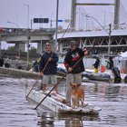 Dos hombres utilizan unas tejas para navegar en una zona inundada el 16 de mayo de 2024, en el municipio de Canoas, estado de Rio Grande do Sul (Brasil).
