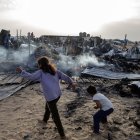 Palestinos entre los daños en un campo de desplazados de Rafah atacado por Israel este 27 de mayo.
