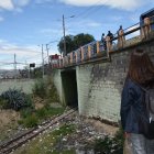 La ciudadana Trinidad Supe observa los rieles por donde antes circulaban los trenes, que actualmente se encuentran llenos de basura y maleza.