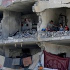 Un hombre palestino y sus hijos en una habitación destruida tras un bombardeo israelí en Rafah