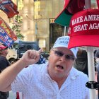Un seguidor del expresidente Donald Trump grita consignas frente a una cámara mientras sostiene una gorra de "Haz a los Estados Unidos grande otra vez" en Nueva York.