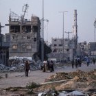 Desplazados internos caminan entre edificios derruidos tras recibir la orden del Ejército israelí de evacuar la localidad de Khan Younis, en la Franja de Gaza.