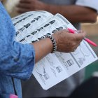 Una funcionaria de casilla revisa una lista electoral para las votaciones este domingo, en la Ciudad de México.