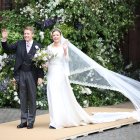 Olivia eligió un traje clásico: recto, escote discreto y manga larga, repleto de encajes. La hombreras bien marcadas y la larga cola complementaron el bellísimo traje de novia. Recogió su melena con un moño alto, y rompió el look con zapatos azules. Debajo del velo, se veía la tiara Myrtle Wreat, pieza de la colección Westminster, elaborada en 1906 por el joyero ruso Fabergé.